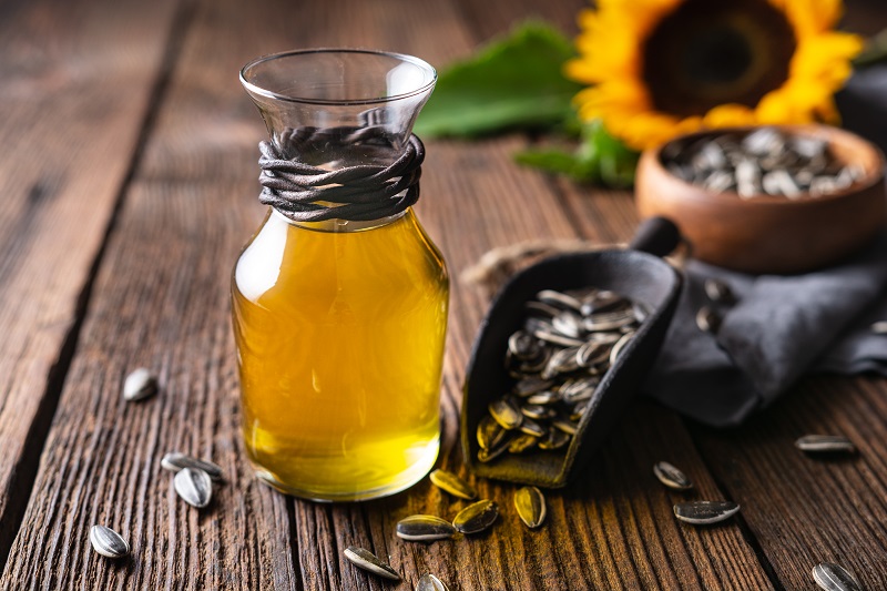 sunflower oil in a glass jar, decorated with whole seeds and flowers